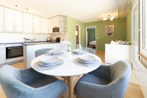 a kitchen and dining room with a white table and chairs at Cozy Swiss Apartment - City & Mountain view in Interlaken