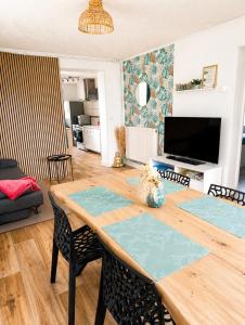 a dining room and living room with a table and chairs at Le petit paradis in Abbeville