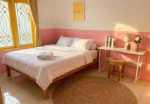 a bedroom with a bed with two towels on it at Decasa Female House in Malang