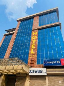 a tall building with a sign on the side of it at Hotel In N Out in Kathmandu