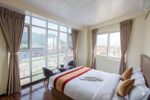 a hotel room with a bed and a large window at Hotel In N Out in Kathmandu