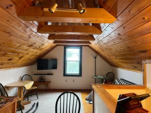 a room with wooden ceilings and a table and chairs at Allegory Inn in Twin Mountain
