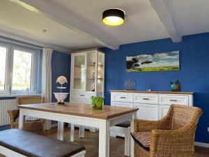 a dining room with blue walls and a table and chairs at Haus-Min-Leevstes in Böhl