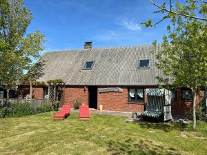 a group of red chairs in front of a brick house at Haus-Min-Leevstes in Böhl