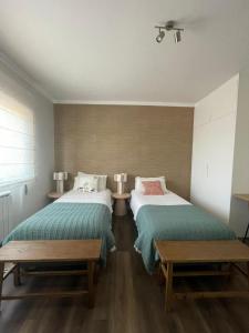 two beds in a room with two tables at Monte da Fonte in Odemira +13 photos