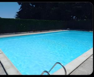 a large blue swimming pool with a fence at Maisonnette de la mer Batz sur mer in Batz-sur-Mer