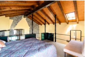 a bedroom with a bed and a chair in a room at The Old Barn by Roby in Saint Vincent