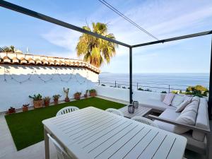 a patio with a white table and chairs and the ocean at Casa de la Plata Punta de la Mona in La Herradura