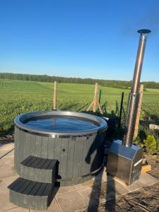 a hot tub in front of a field at Perła prosto z Borów in Cekcyn