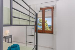 a bedroom with a bunk bed and a window at Villa Damiano in Tertenìa
