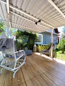 a wooden deck with two chairs and a pergola at Pousada Sítio Bosque in Campina Grande +41 photos