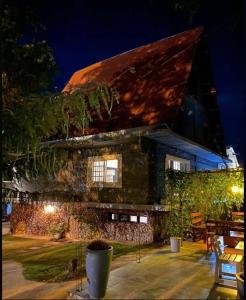 a house with a roof that is lit up at night at Pousada Sítio Bosque in Campina Grande