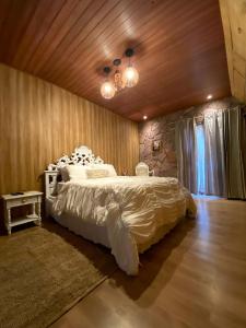 a bedroom with a large bed with white sheets at Pousada Sítio Bosque in Campina Grande