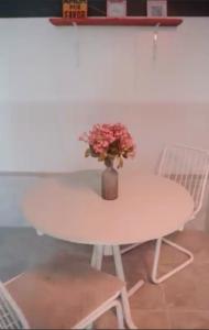 a table and chairs with a vase of flowers on it at Pousada Sítio Bosque in Campina Grande