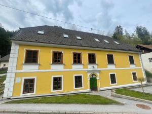 a yellow house with a black roof at Ferienwohnung Raabklamm in Arzberg