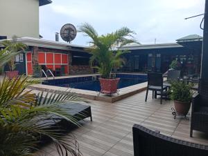 a patio with palm trees and a swimming pool at Visa Karena Hotels in Port Harcourt