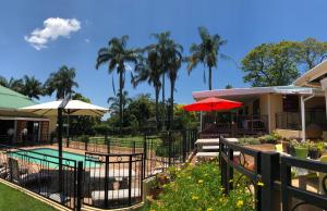 a resort with a swimming pool and palm trees at Golf View Lodge Melmoth in Melmoth