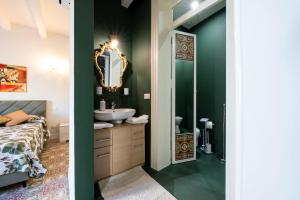 a bathroom with a bed and a sink and a mirror at Chez Moi in Trapani +38 photos