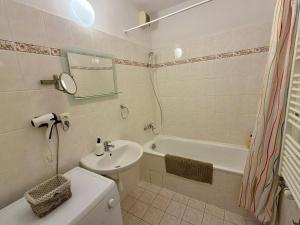 a bathroom with a sink and a toilet and a tub at Richie Apartment near Aquapark in Prague +30 photos