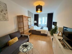 a living room with a couch and a bed in a room at Richie Apartment near Aquapark in Prague