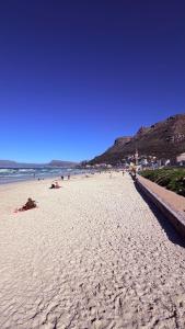 a beach with people laying on the sand at Sunset Beach Self-Catering in Marina da Gama