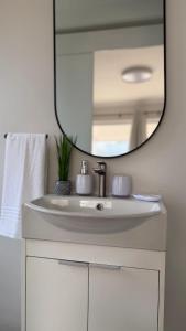 a bathroom with a white sink and a mirror at Sunset Beach Self-Catering in Marina da Gama +61 photos