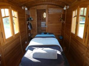 a group of three beds in a train room at Les roulottes Vesta in Léognan
