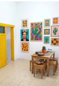 a room with a table and paintings on the wall at Decasa Female House in Malang