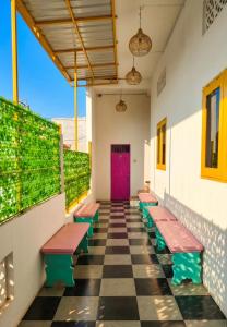 a row of benches in a hallway with a purple door at Decasa Female House in Malang