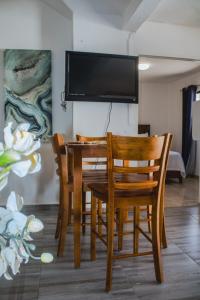 a dining room table with chairs and a flat screen tv at Villa La Dueña Perfect Escape in Las Terrenas