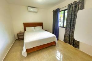 a bedroom with a bed and a window at Villa La Dueña Perfect Escape in Las Terrenas +25 photos