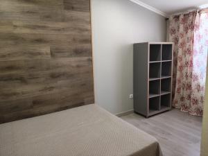 a bedroom with a bed and a wooden wall at Casa Verão Azul in Monte Gordo