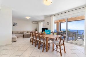 a dining room and living room with a table and chairs at Villa Seliora in Sivota