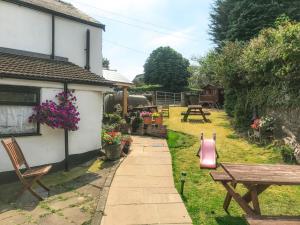 a garden with a bench and a picnic table at Brewery Lodge in Blakeney