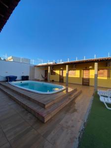 a building with a swimming pool on a patio at Lotus Beach in Piaçabuçu