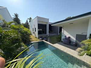 a swimming pool in front of a house at Noir Blanc Modern Villa in Ko Phangan