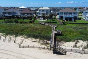 a stairway to the beach with houses in the background at Moss Landing Luxury Beachfront Private Walkover in Bolivar Peninsula
