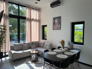 a living room with a couch and a table at Noir Blanc Modern Villa in Ko Phangan