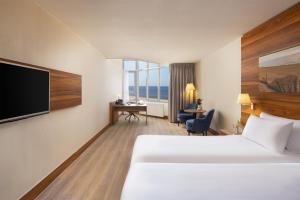 a hotel room with a bed and a flat screen tv at NH Zandvoort Hotel in Zandvoort