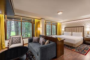 a bedroom with a bed and a couch and a table at Radisson Golf Resort Pahalgam in Pahalgām +128 photos