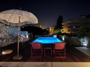 a table with chairs and an umbrella next to a swimming pool at Casa de Ramalde in Porto