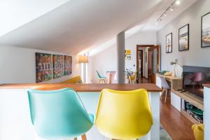 a living room with yellow and blue chairs at Romántico apartamento con piscina in Vargas