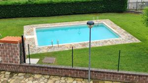 a swimming pool in the grass with a light next to it at Romántico apartamento con piscina in Vargas