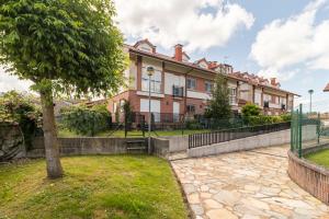 an apartment building with a tree in front of it at Romántico apartamento con piscina in Vargas