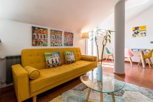 a living room with a yellow couch and a glass table at Romántico apartamento con piscina in Vargas