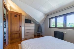 a bedroom with a bed and a tv and a window at La Centinela en Costa Quebrada in Miengo +18 photos