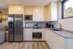 a kitchen with white cabinets and a stainless steel refrigerator at La Centinela en Costa Quebrada in Miengo