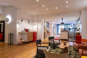 ein Wohnzimmer mit Tisch und Stühlen und eine Küche in der Unterkunft Hotel George - Astotel in Paris