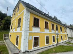 a yellow and white building with windows at Ferienwohnung Sommeralm in Arzberg
