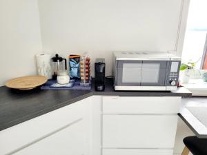 a kitchen counter with a microwave on top of it at Beautiful panoramic apartment in Vestnes